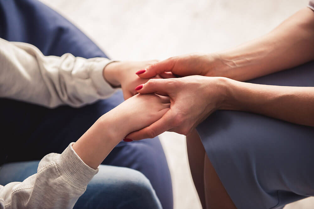 Two people holding hands with focus on the hands